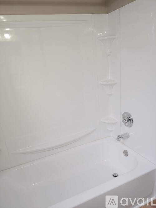A white bathtub with a shower head and faucet.