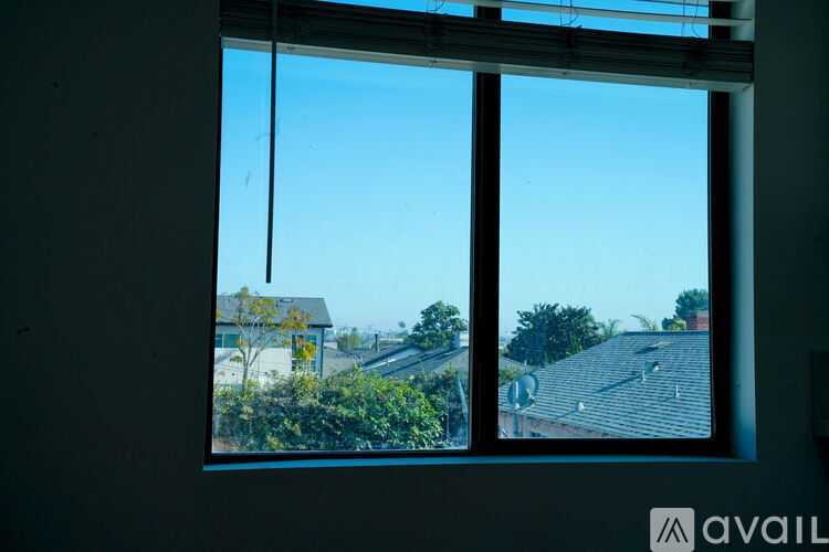 A window with a view of a house and trees.