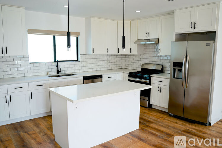 A kitchen with white cabinets and a white island.