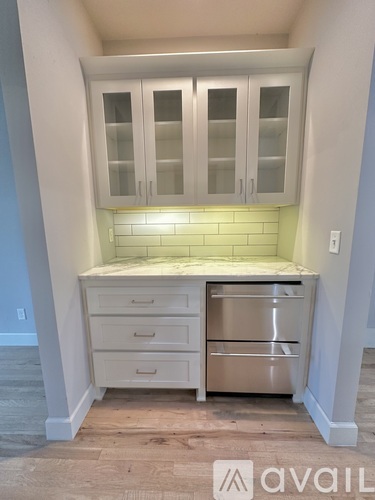 A kitchen with white cabinets and a stainless steel dishwasher.