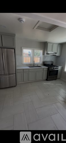 A kitchen with a refrigerator, sink, and stove.