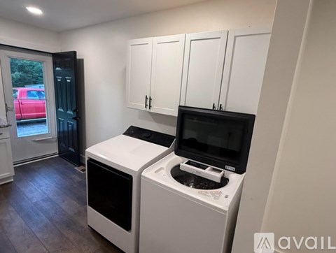 A kitchen with white cabinets and a black microwave.