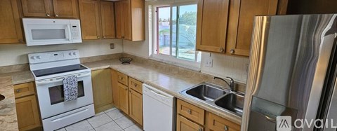 A kitchen with wooden cabinets and a white stove top oven.