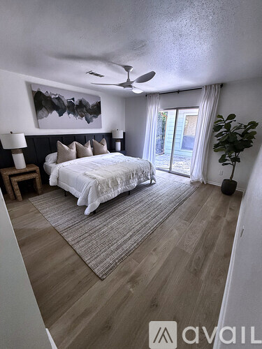 A bedroom with a large bed and a ceiling fan.