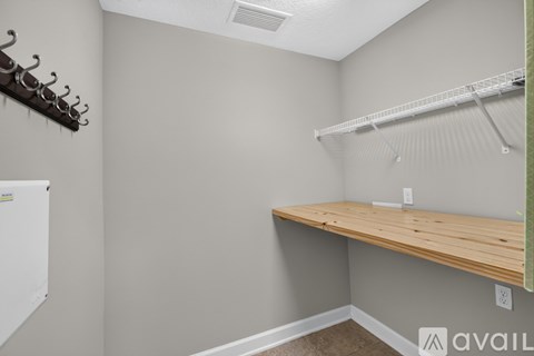 A kitchen with a white fridge, a wooden counter and a white shelf.