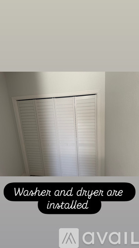 A window with white blinds and a sign that says "Washer and dryer are installed".