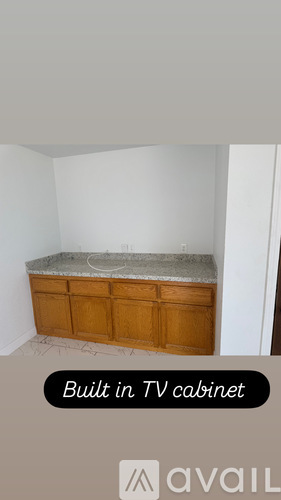 A built in TV cabinet is available in a room with white walls.