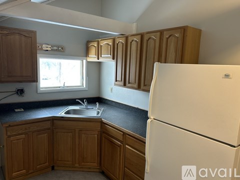 A kitchen with wooden cabinets and a white refrigerator.