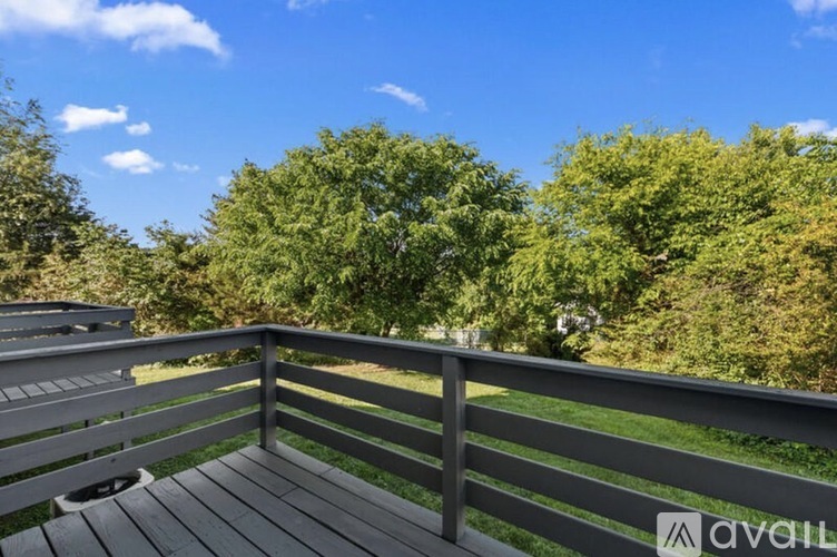 A wooden deck overlooks a grassy area with trees.