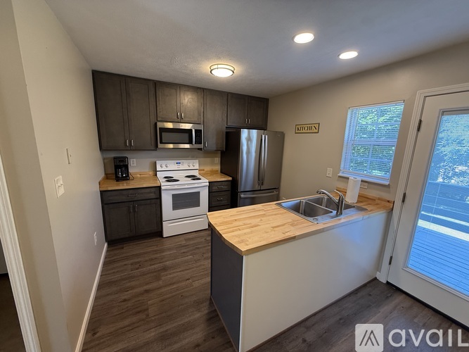 A kitchen with a white stove top oven and a white refrigerator.