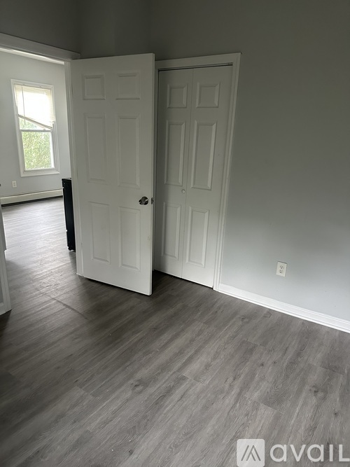 A room with two white doors and a window.