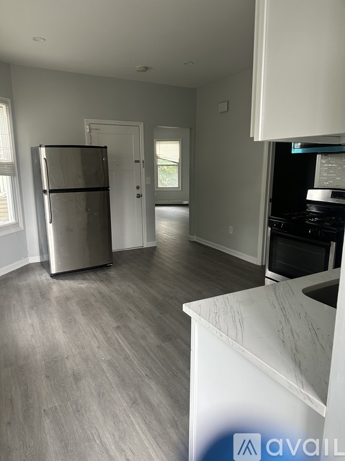 A kitchen with a white counter and a stainless steel refrigerator.