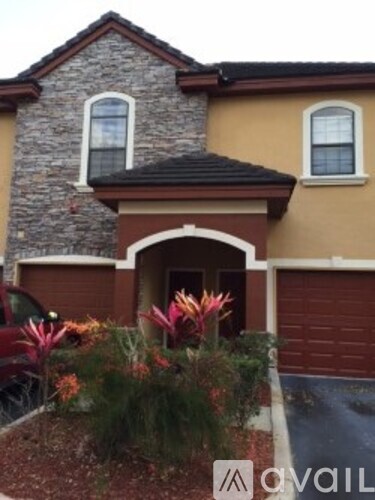A house with a brown garage door and a stone wall.