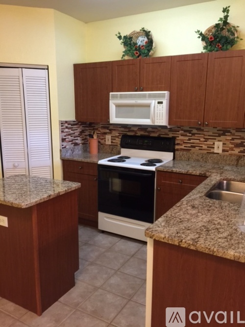 A kitchen with granite countertops and wooden cabinets.
