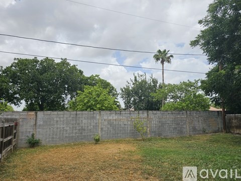 A backyard with a fence and a tree.