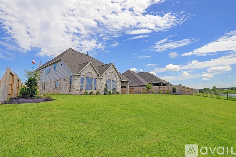 A large house with a fence and a grassy yard.