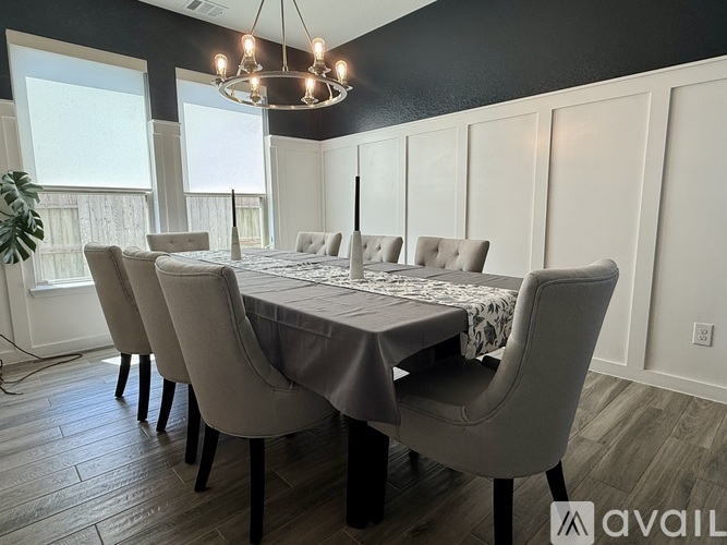 A dining room with a table set for six and a chandelier hanging from the ceiling.