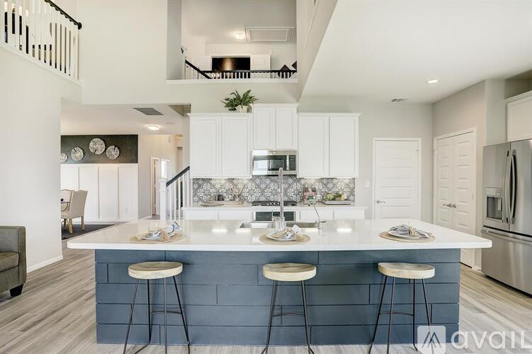A modern kitchen with a large island and bar stools.