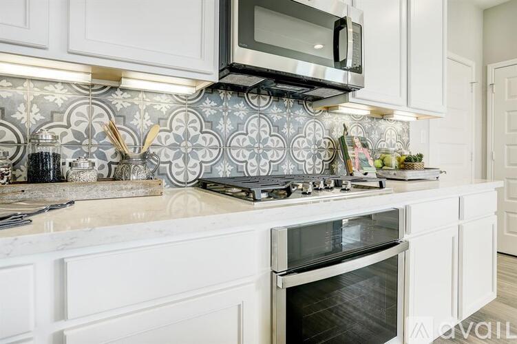 A kitchen with a white countertop and a black microwave above it.