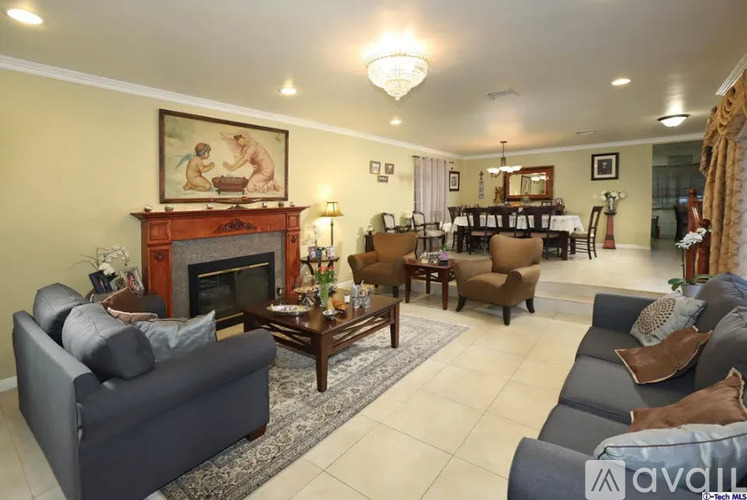 A living room with a fireplace and a painting on the wall.