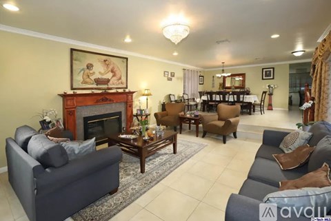A living room with a fireplace and a painting on the wall.