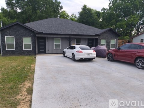 A white car is parked in a driveway next to a red car.