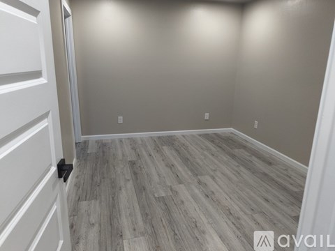 A room with a wooden floor and white walls.