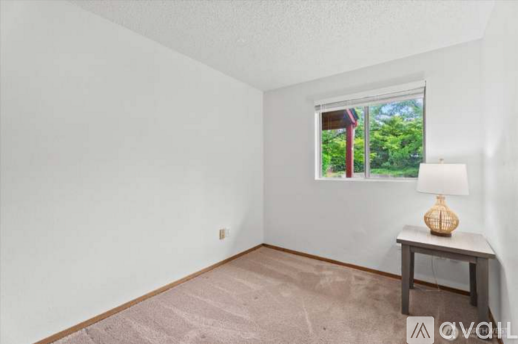 A room with a window, a lamp, and a table.