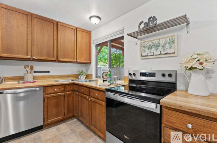A kitchen with wooden cabinets and a stainless steel dishwasher.