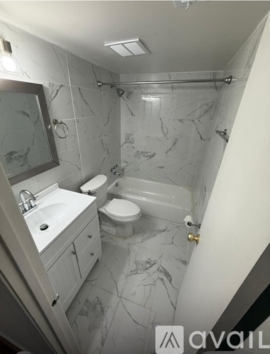 A bathroom with marble tiles and a white sink.