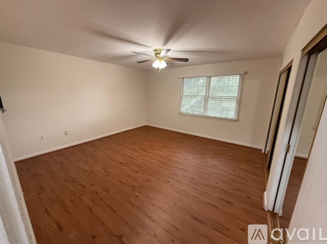 A room with wooden flooring and a ceiling fan.