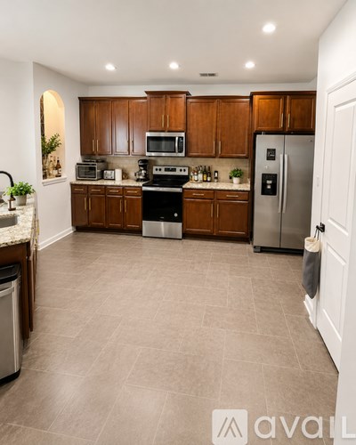 A kitchen with brown cabinets and a tile floor.
