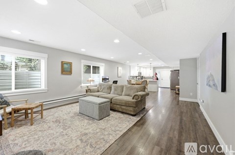 A spacious living room with a grey sofa set and a wooden coffee table.