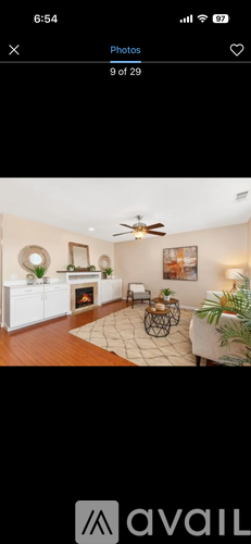 A living room with a fireplace and a ceiling fan.