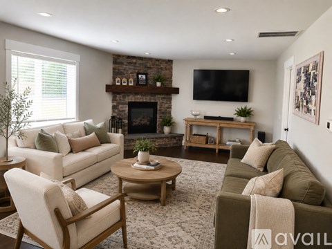 A living room with a fireplace and a television on the wall.