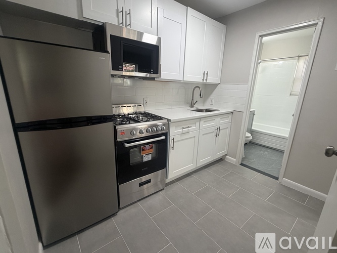 A kitchen with a stainless steel refrigerator and a stove top oven.