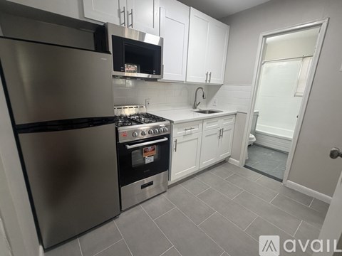 A kitchen with a stainless steel refrigerator and a stove top oven.