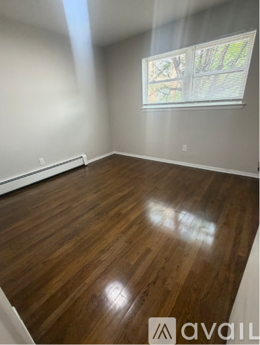 A room with wooden flooring and a window.