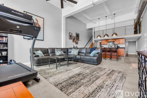 A living room with a grey sofa and a black and white rug.