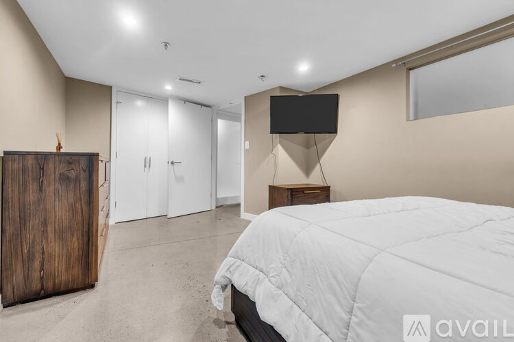 A bedroom with a large bed and a TV on a stand.