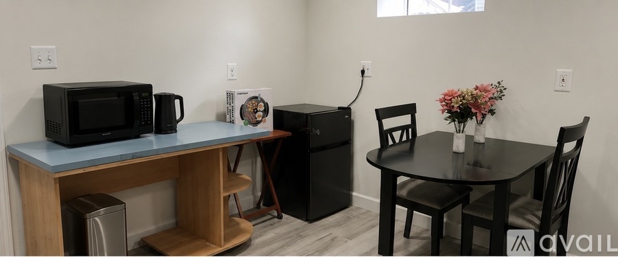 A black microwave is on a blue countertop in a kitchen.