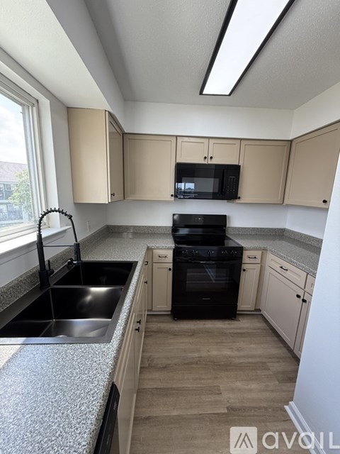 A kitchen with a black oven and a black microwave.