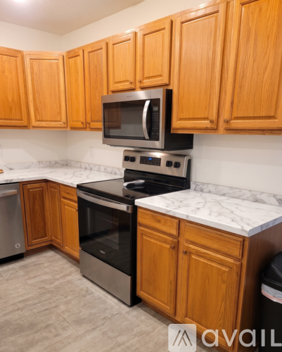 A kitchen with wooden cabinets and a black stove top oven.