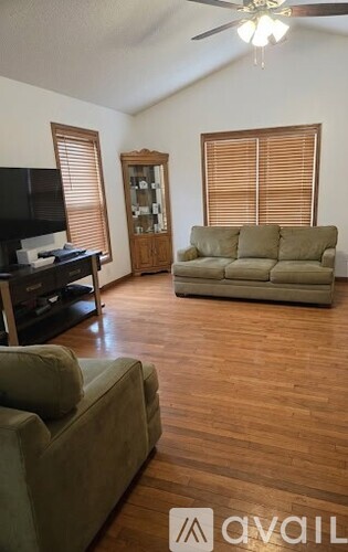 A living room with a couch, a cabinet, and a television.