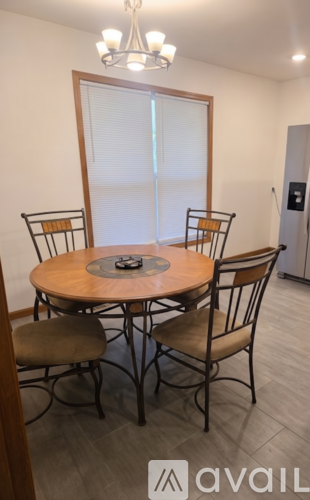 A dining room with a round table and chairs.
