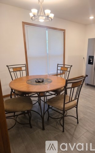 A dining room with a round table and chairs.
