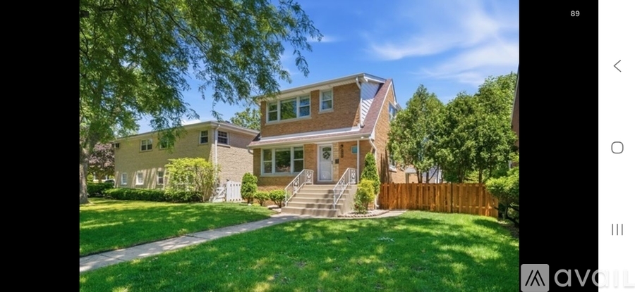 A house with a brown fence and a green lawn.