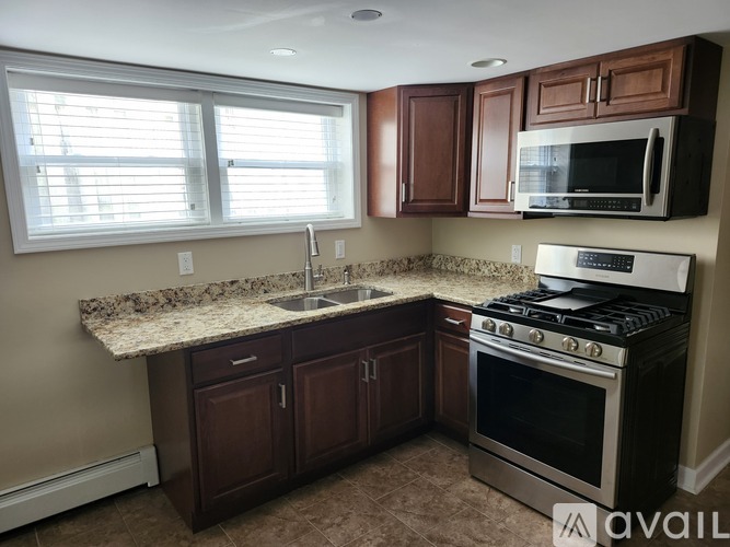 A kitchen with brown cabinets and a granite countertop.