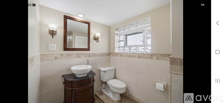 A bathroom with a toilet, sink, and mirror.