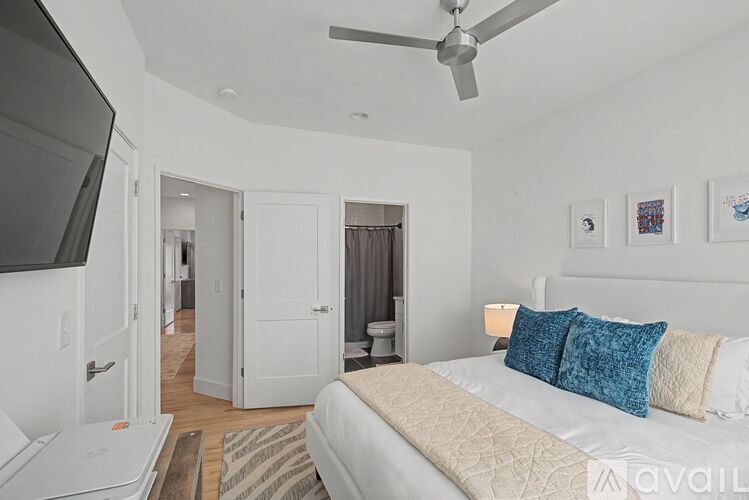 A bedroom with a large bed and a ceiling fan.